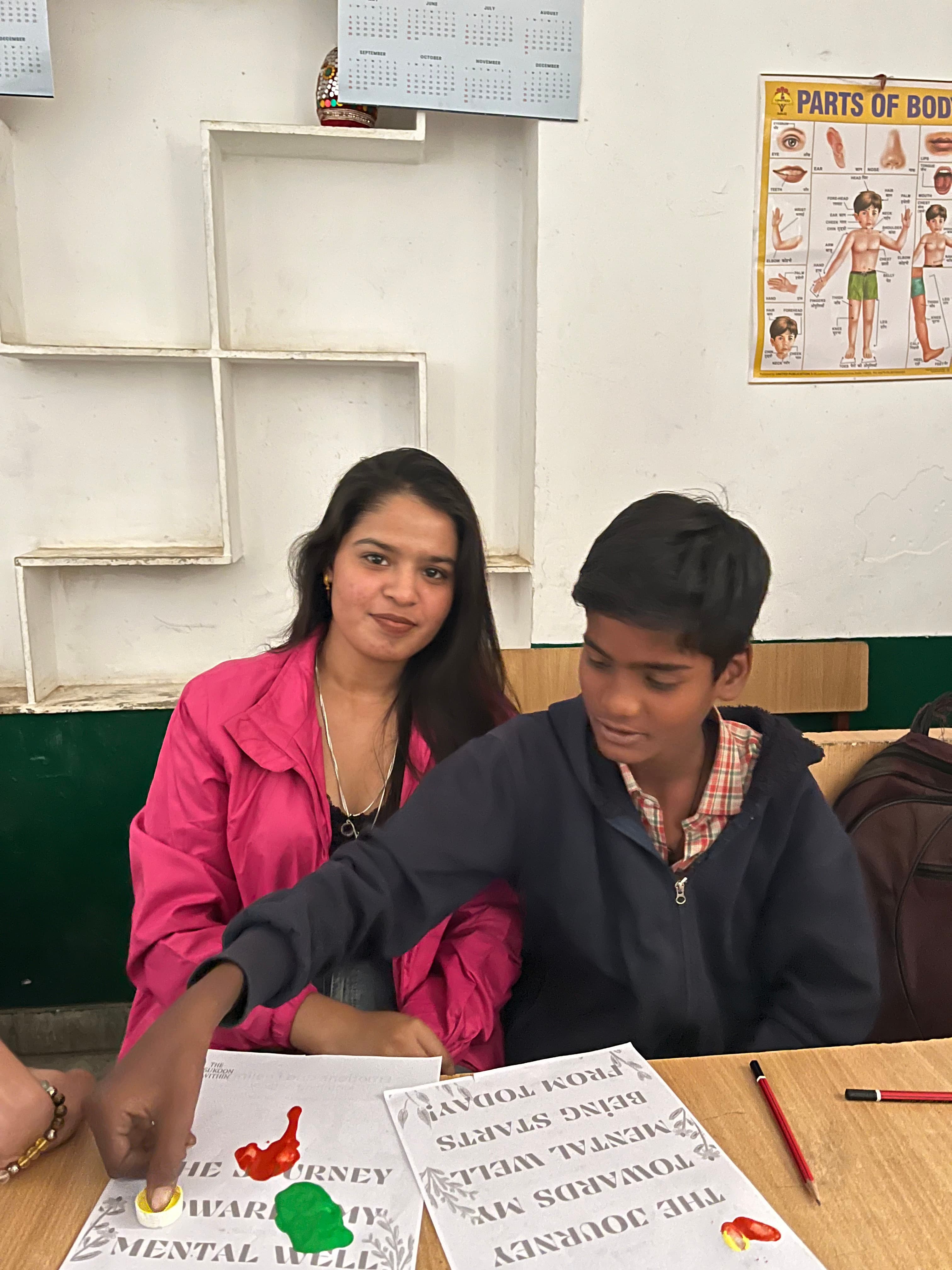 A volunteer supporting a child during a classroom well-being activity