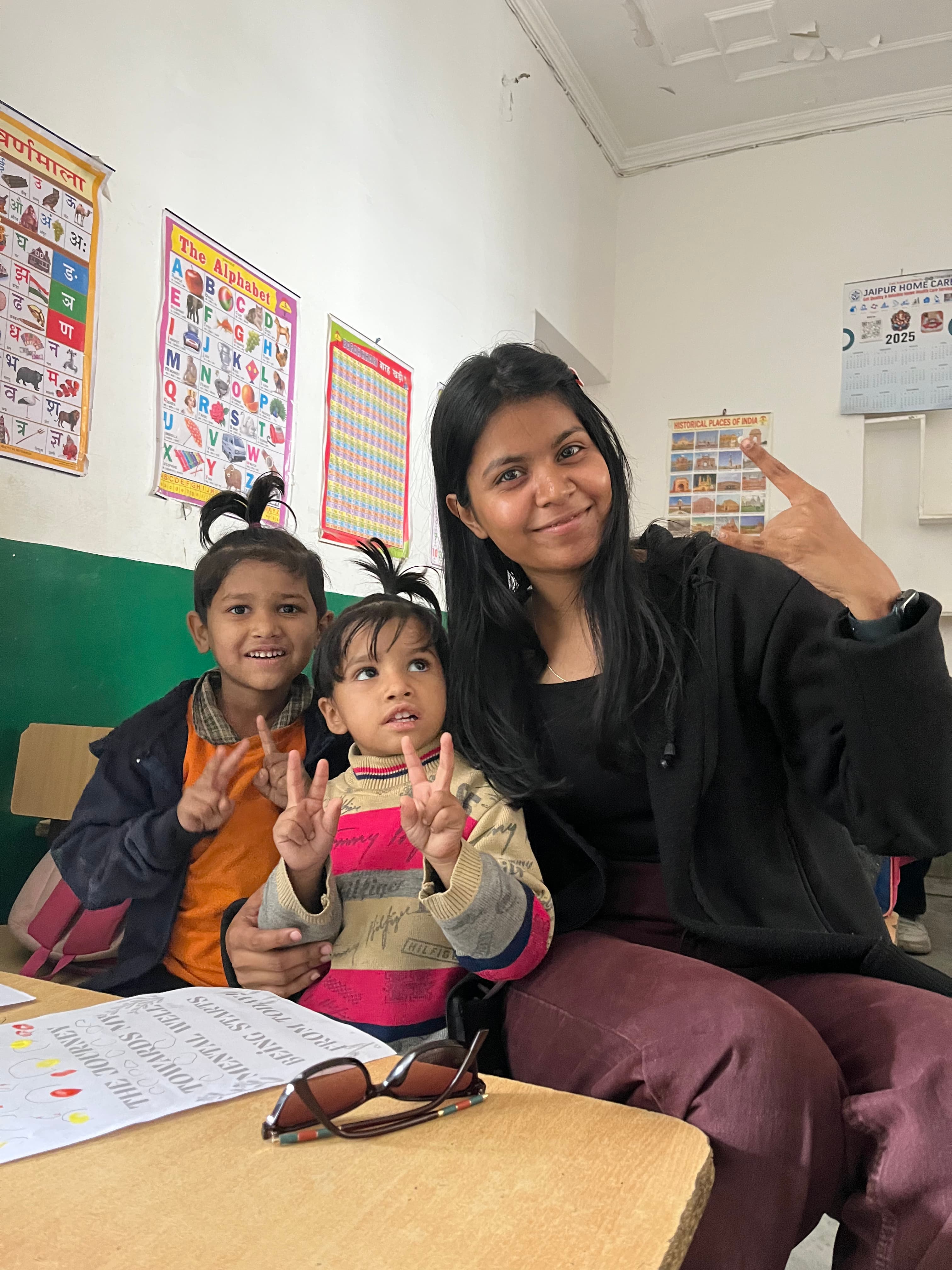 A volunteer sharing a cheerful moment with two children after an activity