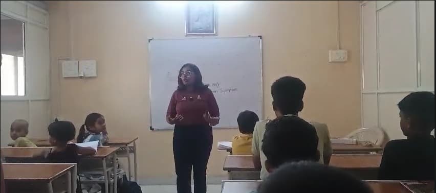 A facilitator speaking with children during a classroom session